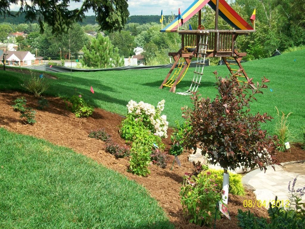 Playground for your backyard surrounded by green grass and flowers