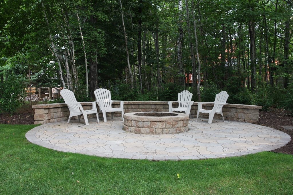 Fire pit in the shade with grass surrounding it