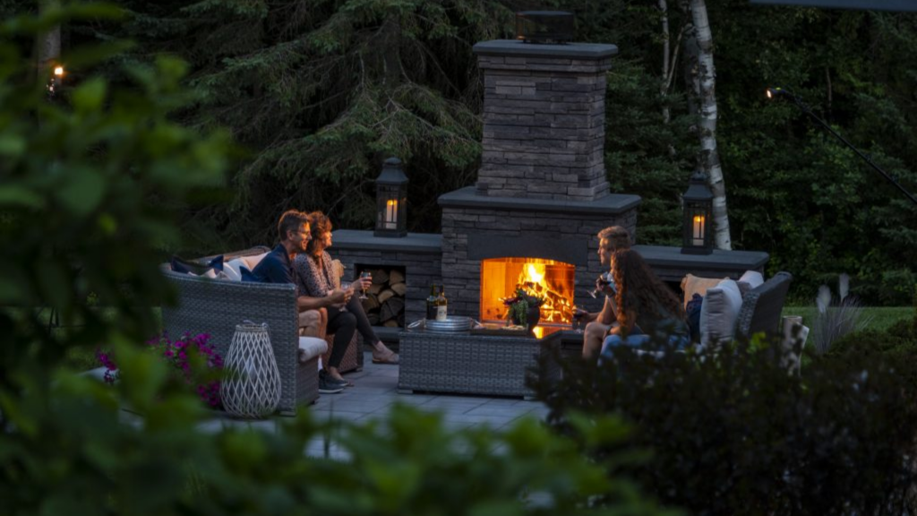 Family sitting by the fire on their outdoor patio